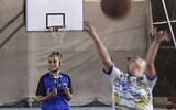 L'arbitre palestinienne Amira Ismail entraîne de jeunes basketteurs à l'Académie des champions dans la ville de Gaza, le 4 octobre 2021 (Crédit ; MOHAMMED ABED / AFP).