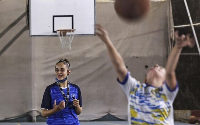 L'arbitre palestinienne Amira Ismail entraîne de jeunes basketteurs à l'Académie des champions dans la ville de Gaza, le 4 octobre 2021 (Crédit ; MOHAMMED ABED / AFP).
