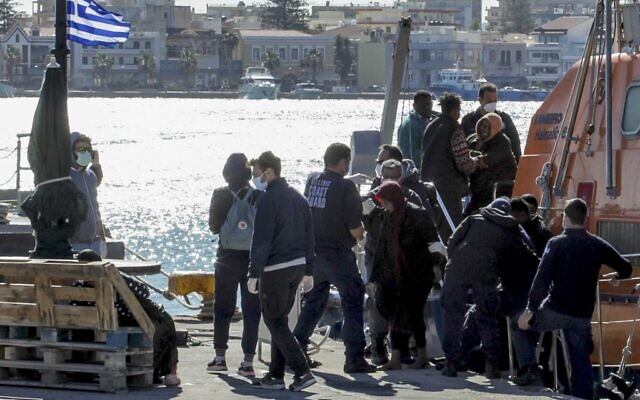 Des migrants débarquent d'un navire des garde-côtes après une opération sur l'île grecque de Chios, le 26 octobre 2021. (Crédit : Dimitris Vouchouris / Eurokinissi / AFP) Des migrants débarquent d'un navire des garde-côtes après une opération sur l'île grecque de Chios, le 26 octobre 2021. (Crédit : Dimitris Vouchouris / Eurokinissi / AFP)