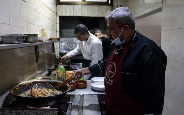 Moïn (à droite) et Mustapha Abou Hassira dans la cuisine du restaurant de poisson Roma appartenant à la famille Abou Hassira à Gaza, le 23 octobre 2021. (Crédit : MOHAMMED ABED / AFP) Moïn (à droite) et Mustapha Abou Hassira dans la cuisine du restaurant de poisson Roma appartenant à la famille Abou Hassira à Gaza, le 23 octobre 2021. (Crédit : MOHAMMED ABED / AFP)