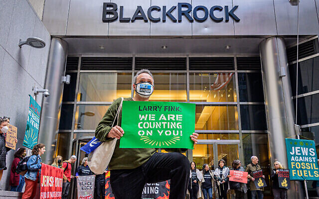 Un manifestant s'agenouille devant le siège de BlackRock à Manhattan, pour demander au PDG de la société d'investissement, Larry Fink, de ne pas financer l'industrie des combustibles fossiles, le 18 octobre 2021. (Crédit : Erik McGregor)