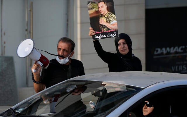 Ibrahim Hoteit, 51 ans, à gauche, et son épouse, Hanan, mènent une manifestation pour les proches des victimes de l'explosion du port de Beyrouth le 4 août 2020 à Beyrouth, au Liban, le samedi 10 juillet 2021. Hoteit, dont le frère a été tué dans l'explosion, est devenu le visage des appels à la justice des familles des victimes. (Crédit : AP/Hassan Ammar)