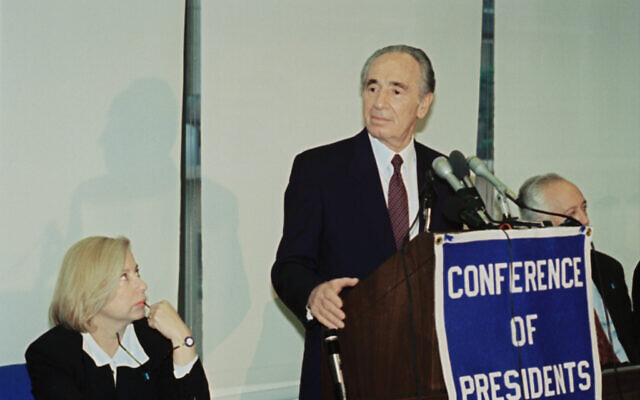 Colette Avital, alors consule général à New York, regarde le ministre des Affaires Etrangères de l'époque, Shimon Peres, s'adresser à la Conférence des présidents des principales organisations juives, le 23 mai 1994, à New York. (Crédit : AP Photo/David Karp) Colette Avital, alors consule général à New York, regarde le ministre des Affaires Etrangères de l'époque, Shimon Peres, s'adresser à la Conférence des présidents des principales organisations juives, le 23 mai 1994, à New York. (Crédit : AP Photo/David Karp)