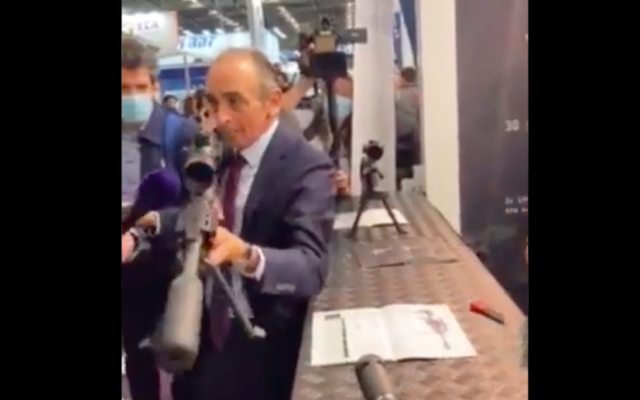 Capture d'écran d'Éric Zemmour en train de pointer un fusil sur des journalistes au salon Milipol, le 20 octobre 2021.