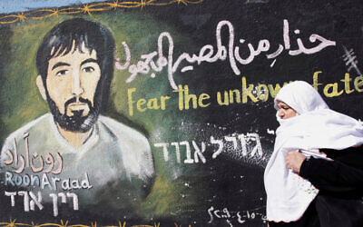 Une Palestinienne passe devant une peinture murale réalisée par un artiste du Hamas représentant le soldat israélien capturé Ron Arad, dans le camp de réfugiés de Jabalia, dans la bande de Gaza, le 28 janvier 2010. (Crédit : Abed Rahim Khatib/Flash90)