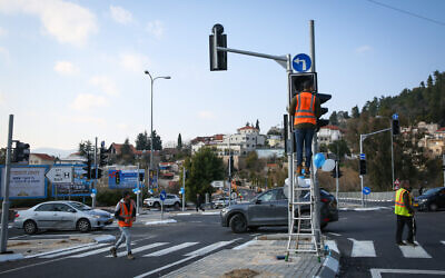 Illustration : des ouvriers actionnent un feu de circulation dans la ville de Tzfat, au nord d'Israël, le 14 janvier 2020. (Crédit : David Cohen/Flash90)