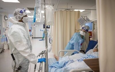 Des employés de l'unité de prise en charge du coronavirus, portant leurs équipements de protection, à l'hôpital Shaare Zedek de Jérusalem, le 23 septembre 2021. (Crédit : Yonatan Sindel/Flash90)