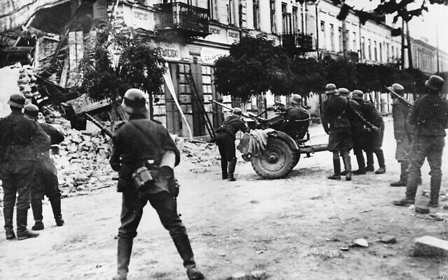 Des soldats allemands tentent de déloger des tireurs d'élite à Varsovie pendant l'invasion nazie de la Pologne en septembre 1939, lors de la Seconde Guerre mondiale. (Crédit : AP Photo)