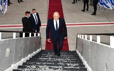 Le Premier ministre Naftali Bennett monte à bord de l'avion à l'aéroport Ben Gourion, pour assister au sommet des Nations unies sur le climat à Glasgow, le 31 octobre 2021. (Crédit : Haim Zach/GPO)