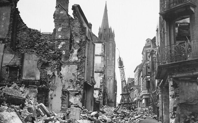 Sur cette photo fournie par l'US Army Signal Corps, une tour Eiffel miniature vacille au milieu des débris dans une rue de la ville française de Coutances, fortement contestée par les Allemands et les Américains, le 3 août 1944. La flèche de la cathédrale de la ville est à l'arrière-plan. (Crédit : AP Photo/U.S. Army Signal Corps)