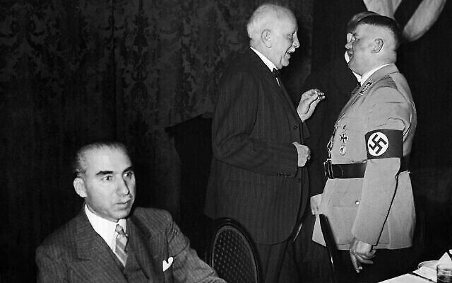 Ernst Roehm, membre du parti nazi, ministre et cofondateur des SA, à droite, discute avec le célèbre compositeur Richard Strauss, au centre, à Berlin le 7 décembre 1933. À gauche, assis, l'ambassadeur turc Kemaleddin Pasha. (Crédit : photo AP)