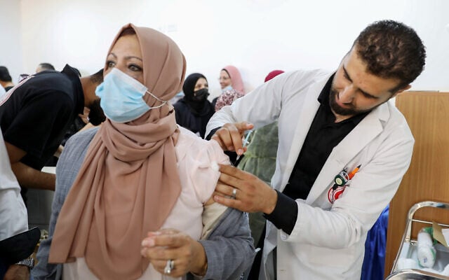 Des Palestiniens reçoivent le vaccin COVID-19 de Pfizer-BioNTech dans la ville d'Hébron, en Cisjordanie, le 27 mars 2021 (Crédit : Wisam Hashlamoun/Flash90). Des Palestiniens reçoivent le vaccin COVID-19 de Pfizer-BioNTech dans la ville d'Hébron, en Cisjordanie, le 27 mars 2021 (Crédit : Wisam Hashlamoun/Flash90).