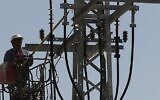 Image illustrative d'un ouvrier d'Israel Electric Corporation hissé par une grue sur un poteau électrique pour effectuer des travaux de maintenance, à l'extérieur de Jérusalem, le 10 juin 2013. (Crédit : Flash 90)