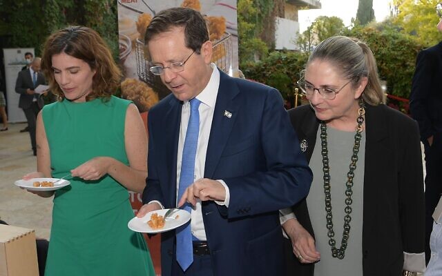 Avec à sa droite son épouse Michal et à sa gauche la ministre de la Protection environnementale Tamar Zandberg, le président Isaac Herzog goûte du poulet fabriqué à partie de cellules cultivées en laboratoire à la résidence du président de Jérusalem, le 25 octobre 2021. (Crédit : Amos Ben Gershom/ GPO) Avec à sa droite son épouse Michal et à sa gauche la ministre de la Protection environnementale Tamar Zandberg, le président Isaac Herzog goûte du poulet fabriqué à partie de cellules cultivées en laboratoire à la résidence du président de Jérusalem, le 25 octobre 2021. (Crédit : Amos Ben Gershom/ GPO)