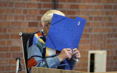 L'accusé Josef Schuetz se couvre le visage alors qu'il est assis dans la salle du tribunal à Brandenburg, en Allemagne, jeudi 7 octobre 2021. (AP Photo/Markus Schreiber)