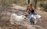 Elishya Ben Meir, une Israélienne de 18 ans, et son chien, ramassent des déchets avec l'application mobile "Clean Coin" à Kiryat Tiv'on, près de la ville de Haïfa, dans le nord d'Israël, le 20 octobre 2021. (Crédit : JACK GUEZ / AFP)
