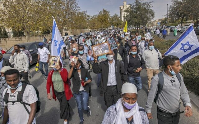 Israelis from the Ethiopian community hold photographs of their relatives during a demonstration demanding the rescue of their relatives left behind amidst the conflict in Ethiopia, outside the Prime Minister's office on Kaplan Street in Jerusalem on November 14, 2021. (Photo by AHMAD GHARABLI / AFP) Israelis from the Ethiopian community hold photographs of their relatives during a demonstration demanding the rescue of their relatives left behind amidst the conflict in Ethiopia, outside the Prime Minister's office on Kaplan Street in Jerusalem on November 14, 2021. (Photo by AHMAD GHARABLI / AFP)