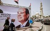 Des femmes passent devant une bannière géante représentant le président égyptien Abdel Fattah al-Sissi au milieu des préparatifs pour recevoir une délégation des services de renseignement égyptiens en visite dans la ville de Gaza, le 31 mai 2021. (Crédit : MOHAMMED ABED / AFP)