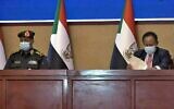 Une capture d'une vidéo de l'AFPTV montre le haut général soudanais Abdel Fattah al-Burhan (à gauche) et le Premier ministre Abdalla Hamdok lors d'une cérémonie de signature d'un accord visant à rétablir la transition vers un régime civil dans le pays dans la capitale Khartoum, le 21 novembre 2021 (Crédit : AFP)