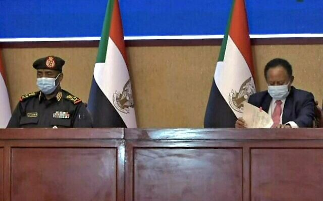 Une capture d'une vidéo de l'AFPTV montre le haut général soudanais Abdel Fattah al-Burhan (à gauche) et le Premier ministre Abdalla Hamdok lors d'une cérémonie de signature d'un accord visant à rétablir la transition vers un régime civil dans le pays dans la capitale Khartoum, le 21 novembre 2021 (Crédit : AFP) Une capture d'une vidéo de l'AFPTV montre le haut général soudanais Abdel Fattah al-Burhan (à gauche) et le Premier ministre Abdalla Hamdok lors d'une cérémonie de signature d'un accord visant à rétablir la transition vers un régime civil dans le pays dans la capitale Khartoum, le 21 novembre 2021 (Crédit : AFP)