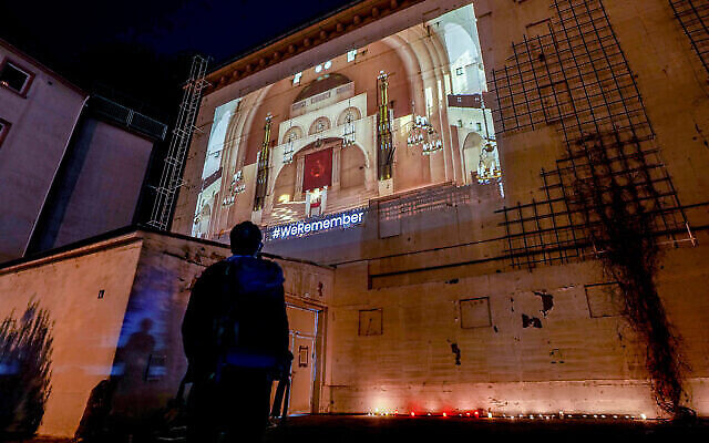 Une photo de la synagogue qui se trouvait jadis à cet endroit projetée sur un bunker à Francfort, en Allemagne, le 9 novembre 2021, lors d'un événement commémoratif organisé à l'occasion du 83e anniversaire de la Nuit de cristal, pogrom antisémite mené par les nazis en 1938. (Crédit : AP Photo/ Michel Probst)