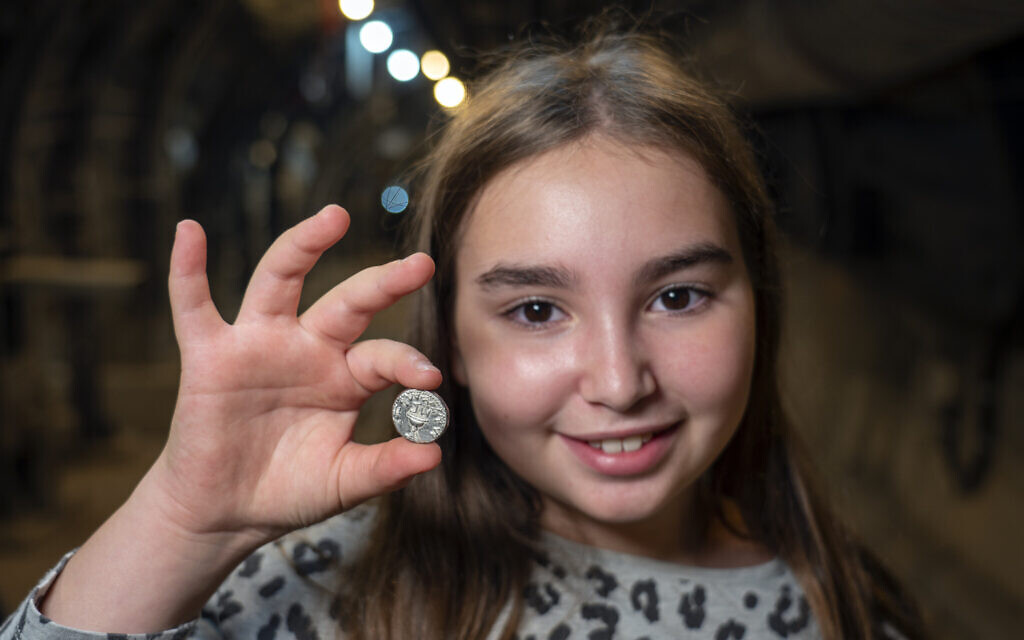 Liel Krutokop, avec la pièce rare qu'elle a découverte. (Crédit :  Yaniv Berman/Cité de David et Autorité israélienne des antiquités)