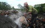 Elieser Rodriguez émerge, noirci, de l'épaisse fumée des bûchers qui transforment lentement les membres des mangroves en charbon de bois - un moyen de subsistance très décrié par les défenseurs de l'environnement et du climat au Panama. (Crédit : AFPTV)