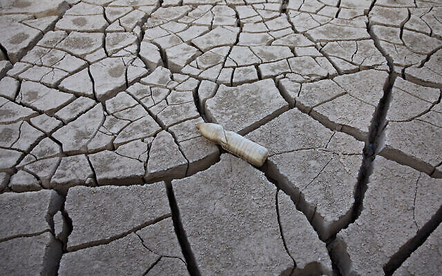 Une bouteille en plastique vide sur la terre craquelée de la rivière Shlomo, près d'Eilat, le 3 novembre 2021. (Crédit :AP Photo/Oded Balilty)