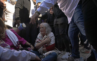 Une membre des Femmes du mur avec un rouleau de la Torah, alors qu'elle est entourée par les forces de sécurité israéliennes qui retiennent les manifestants au Mur occidental dans la Vieille Ville de Jérusalem, le 5 novembre 2021. (Crédit : AP Photo/Maya Alleruzzo)