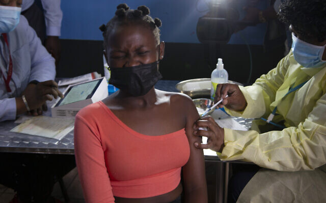 Une jeune femme se fait vacciner contre le coronavirus avec le vaccin Pfizer près de Johannesburg, le 21 octobre 2021. (Crédit : AP Photo/Denis Farrell, File)