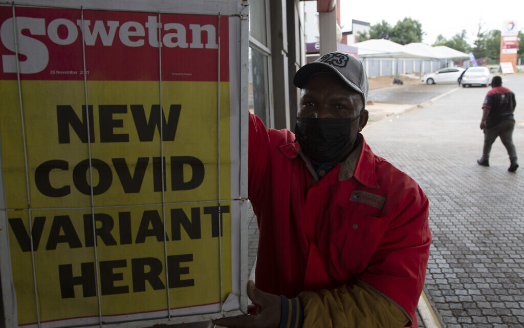 Un employé de station service près d'une affiche promotionnelle de journal à Pretoria, en Afrique du sud, le 27 novembre 2021. (Crédit : AP Photo/Denis Farrell) Un employé de station service près d'une affiche promotionnelle de journal à Pretoria, en Afrique du sud, le 27 novembre 2021. (Crédit : AP Photo/Denis Farrell)
