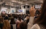 Une femme prend une vidéo de Oliver Barker, commissaire-priseur de Sotheby's, qui dirige une vente aux enchères de la collection Macklowe, chez Sotheby's, le 15 novembre 2021 à New York. (Crédit : Yuki IWAMURA / AFP)