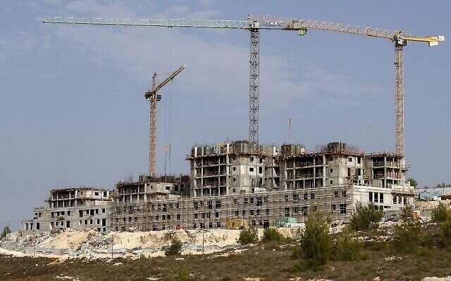Travaux de construction dans l'implantation israélienne de Givat Zeev, près de la ville palestinienne de Ramallah, en Cisjordanie, le 28 octobre 2021. (Crédit : Ahmad Gharabli/AFP) Travaux de construction dans l'implantation israélienne de Givat Zeev, près de la ville palestinienne de Ramallah, en Cisjordanie, le 28 octobre 2021. (Crédit : Ahmad Gharabli/AFP)
