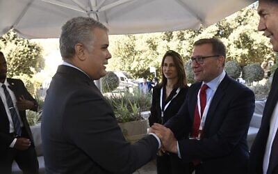 Le président colombien Ivan Duque, à gauche, serre la main de l'ambassadeur israélien en Colombie, Christian Cantor, à Jérusalem, le 9 novembre 2021. (Crédit :  Jorge Novominski)