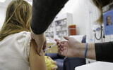 Une Israélienne une troisième dose du vaccin COVID-19 dans un centre de soins à Katzrin, sur le plateau du Golan, le 16 novembre 2021. (Crédit : Michael Giladi/Flash90)