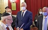 Le ministre israélien de la Défense Benny Gantz écoute une prière de Gavriel Dery, membre de la communauté juive locale, lors d'une visite à la synagogue Talmud Torah de Rabat, le 25 novembre 2021. (Crédit : Jonah MANDEL / AFP)