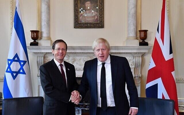 Le Premier ministre britannique Boris Johnson (à droite) serre la main du président israélien Isaac Herzog avant des entretiens au numéro 10 de Downing Street, dans le centre de Londres, le 23 novembre 2021, pendant la visite de trois jours du président israélien. (Crédit : JUSTIN TALLIS / POOL / AFP)