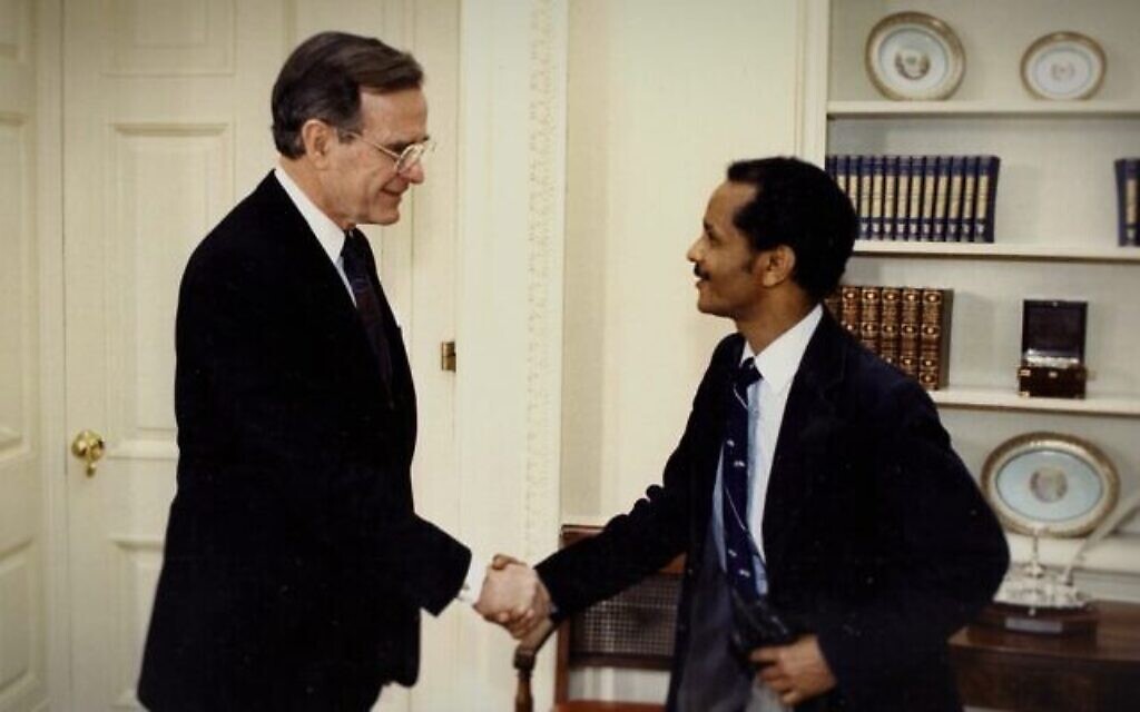 L'ancien président américain George H.W. Bush serre la main de l'activiste éthiopien Rahamim Elazar. (Crédit : avec l'aimable autorisation de Black and White Films)