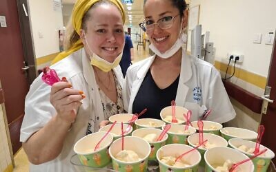 Le personnel de l'hôpital Sheba distribue des glaces riches en nutriments aux patients gériatriques (Crédit : Naama Frank Azriel)