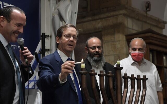 Le président Isaac Herzog allume une bougie de Hanoukka à Hébron le 28 novembre 2021. (Crédit : Kobi Gideon/GPO)