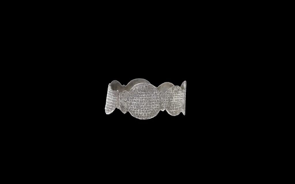 La manchette en argent vieille de 1 500 ans, sur laquelle sont inscrits les mots de la prière du Shema en grec, est au centre de l'exposition " Hear, O Israel : The Magic of the Shema", archéologique au Musée d'Israël qui se terminera en avril 2022. (Crédit : Laura Lachman) La manchette en argent vieille de 1 500 ans, sur laquelle sont inscrits les mots de la prière du Shema en grec, est au centre de l'exposition " Hear, O Israel : The Magic of the Shema", archéologique au Musée d'Israël qui se terminera en avril 2022. (Crédit : Laura Lachman)