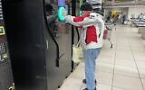 Un client essaie le distributeur automatique de bouteilles dans une succursale de la chaîne de supermarchés Yochananoff à Talpiot, au sud de Jérusalem, le 23 novembre 2021. (Sue Surkes/Times of Israel)