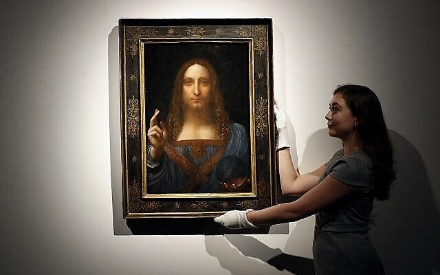 Sur cette photo du 24 octobre 2017, un employé pose avec le "Salvator Mundi" de Léonard de Vinci exposé dans les salles de vente de Christie's à Londres. (AP Photo/Kirsty Wigglesworth) Sur cette photo du 24 octobre 2017, un employé pose avec le "Salvator Mundi" de Léonard de Vinci exposé dans les salles de vente de Christie's à Londres. (AP Photo/Kirsty Wigglesworth)