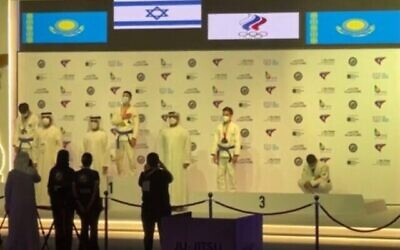 Un compétiteur kazakh de jiu jitsu s'agenouille pendant que l'hymne national israélien, 'Hatikvah', est joué lors de la cérémonie de remise des médailles aux Championnats du monde à Abu Dhabi, le 9 novembre 2021. (Capture d'écran)