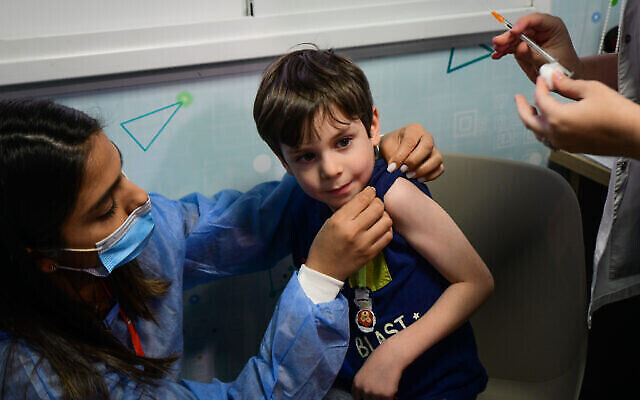 Un garçon israélien Itamar, 5 ans, reçoit une dose du vaccin Pfizer/BioNTech Covid-19 à l'Organisation des services de santé Meuhedet à Tel Aviv, le 22 novembre 2021, alors qu'Israël commence sa campagne de vaccination contre le coronavirus pour les enfants de 5 à 11 ans. (Crédit : JACK GUEZ / AFP) Un garçon israélien Itamar, 5 ans, reçoit une dose du vaccin Pfizer/BioNTech Covid-19 à l'Organisation des services de santé Meuhedet à Tel Aviv, le 22 novembre 2021, alors qu'Israël commence sa campagne de vaccination contre le coronavirus pour les enfants de 5 à 11 ans. (Crédit : JACK GUEZ / AFP)