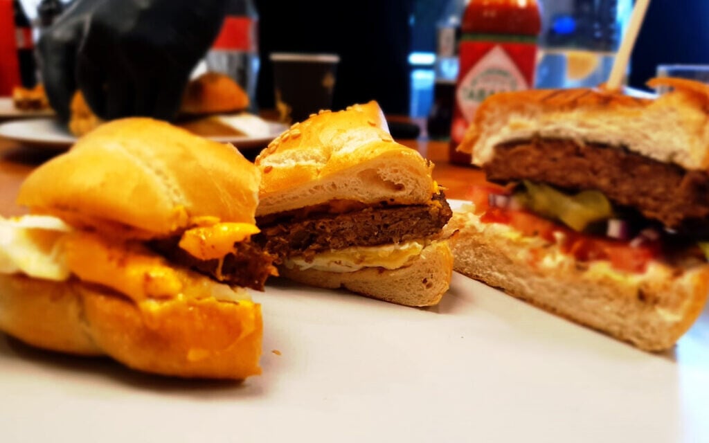 Le burger de bœuf à base de plantes de SavorEat (à droite) et la galette de saucisse de porc pour le petit-déjeuner (à gauche), servis dans la cuisine de l'entreprise à Rehovot, en novembre 2021. (Personnel du Times of Israel)