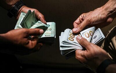 Des personnes échangent des billets en livres libanaises et en dollars américains sur le marché noir à Beyrouth, la capitale du Liban, le 18 juin 2020. (Crédit : JOSEPH EID / AFP)