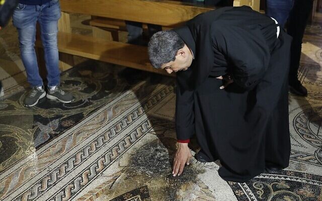 Photo d'illustration : Un prêtre inspecte les dégâts après qu'un homme a aspergé le sol de l'église de toutes les nations, dans le jardin de Gethsemane, de liquide inflammable, à Jérusalem-Est, le 4 décembre 2020. (Crédit : Ahmad Gharabli/AFP) Photo d'illustration : Un prêtre inspecte les dégâts après qu'un homme a aspergé le sol de l'église de toutes les nations, dans le jardin de Gethsemane, de liquide inflammable, à Jérusalem-Est, le 4 décembre 2020. (Crédit : Ahmad Gharabli/AFP)