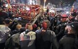 Une foule palestinienne autour d'un véhicule incendié après que deux Israéliens sont entrés, en voiture, dans la ville de Ramallah en Cisjordanie, le 1er décembre 2021. (Crédit : ABBAS MOMANI / AFP)