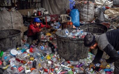 Des réfugiés afghans ramassent des déchets dans une décharge, le 18 novembre 2021, à Istanbul. (Crédit : Bulent KILIC / AFP) Des réfugiés afghans ramassent des déchets dans une décharge, le 18 novembre 2021, à Istanbul. (Crédit : Bulent KILIC / AFP)
